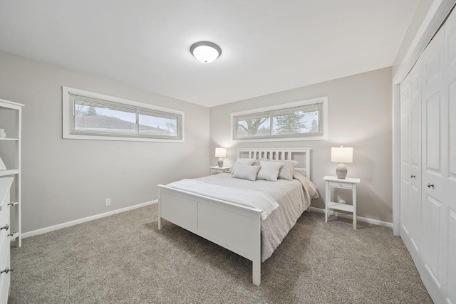 carpeted bedroom featuring a closet and baseboards