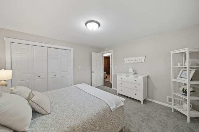 bedroom featuring baseboards, a closet, visible vents, and carpet
