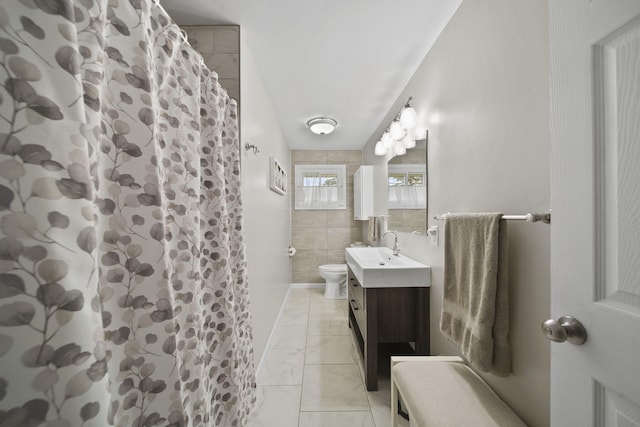 full bath featuring vanity, tile walls, marble finish floor, toilet, and a shower with shower curtain