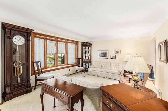 living area with visible vents and light carpet