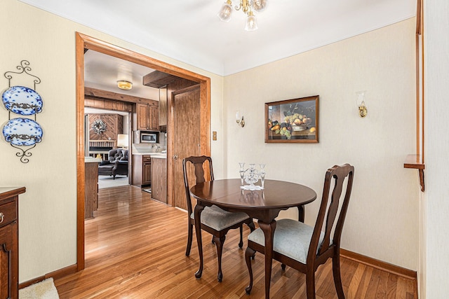 dining area featuring baseboards and light wood finished floors