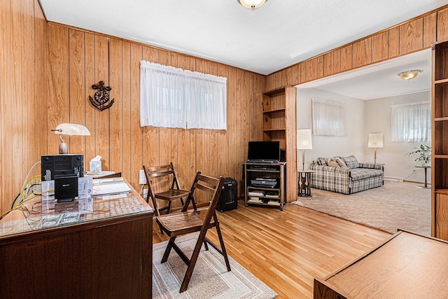 office area featuring light wood-type flooring and wood walls