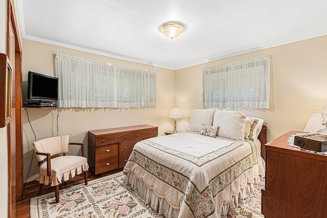 bedroom with ornamental molding and light wood finished floors
