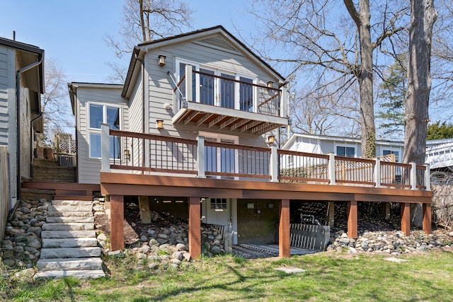 back of property with a wooden deck, a lawn, and a balcony