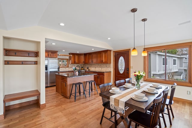 dining area featuring recessed lighting, baseboards, vaulted ceiling, and light wood-type flooring