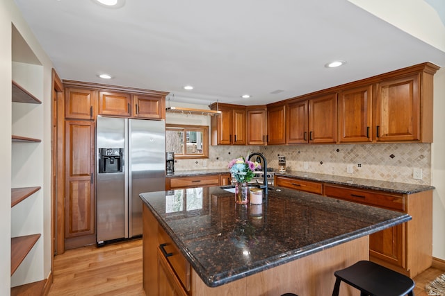 kitchen featuring brown cabinets, light wood-type flooring, stainless steel refrigerator with ice dispenser, and open shelves