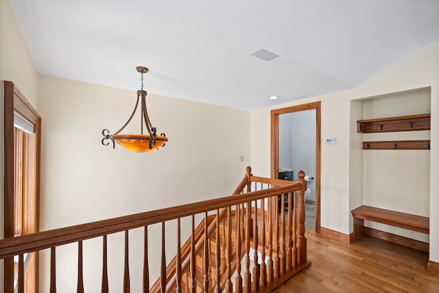 corridor with an upstairs landing, light wood-style floors, baseboards, visible vents, and recessed lighting