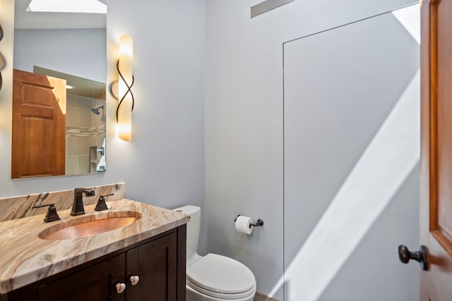 bathroom with toilet, vanity, and a shower