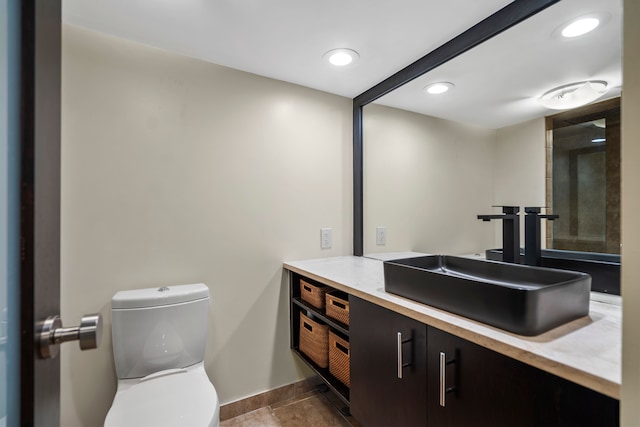 bathroom with vanity, baseboards, toilet, tile patterned flooring, and recessed lighting