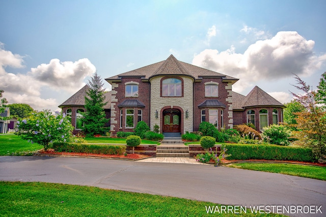 3550 64th Ave, Zeeland, MI 49464 - french country inspired facade with french doors, a front yard, brick siding, and a shingled roof