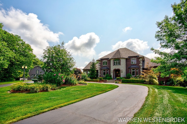 3550 64th Ave, Zeeland, MI 49464 - french provincial home with a front lawn, curved driveway, and stone siding