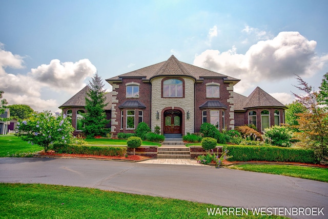 3550 64th Ave, Zeeland, MI 49464 - french provincial home featuring french doors, brick siding, a front lawn, and roof with shingles