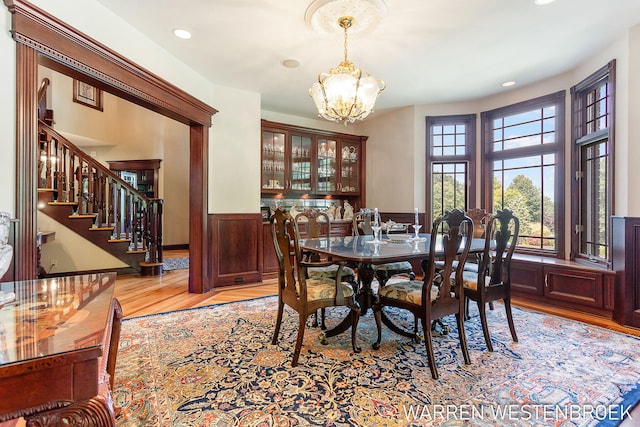 3550 64th Ave, Zeeland, MI 49464 - dining room with a chandelier, light wood-type flooring, a wainscoted wall, stairway, and recessed lighting
