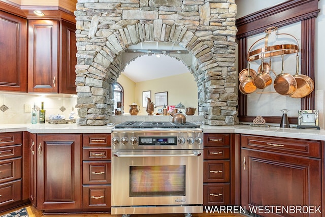 3550 64th Ave, Zeeland, MI 49464 - kitchen with high end stainless steel range, light countertops, arched walkways, dark brown cabinets, and lofted ceiling