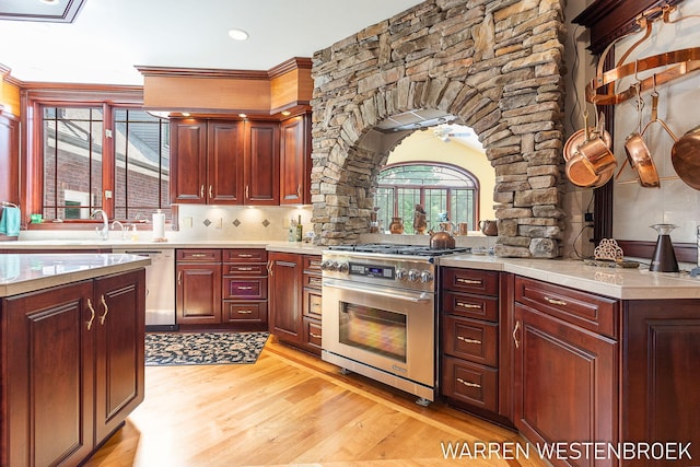 3550 64th Ave, Zeeland, MI 49464 - kitchen with appliances with stainless steel finishes, decorative columns, light wood-type flooring, light countertops, and crown molding