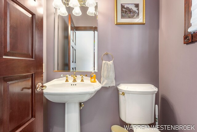 3550 64th Ave, Zeeland, MI 49464 - bathroom featuring toilet and a chandelier