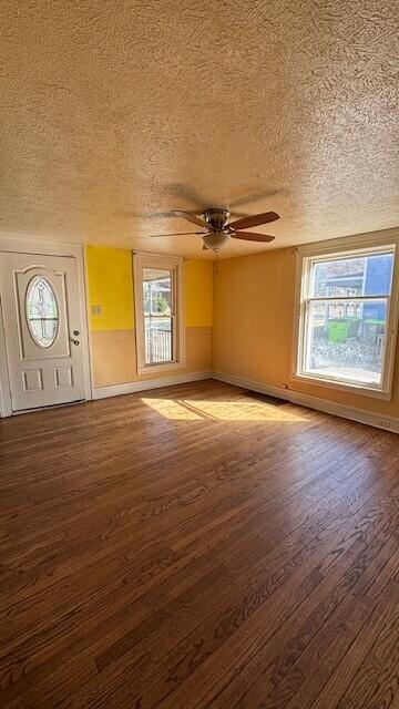 interior space featuring a ceiling fan, wood finished floors, and a textured ceiling