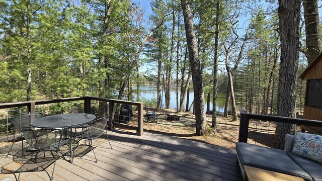 wooden deck featuring outdoor dining area and a water view