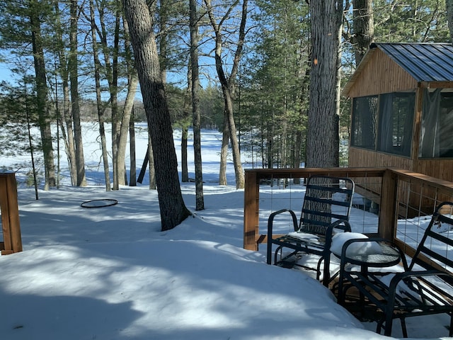snowy yard with a sunroom and stairway