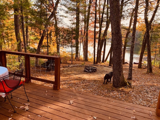 wooden terrace with a water view and an outdoor fire pit