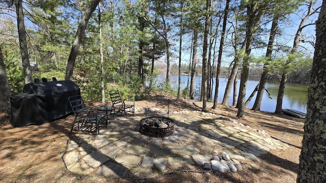 view of patio / terrace featuring a fire pit, grilling area, and a water view