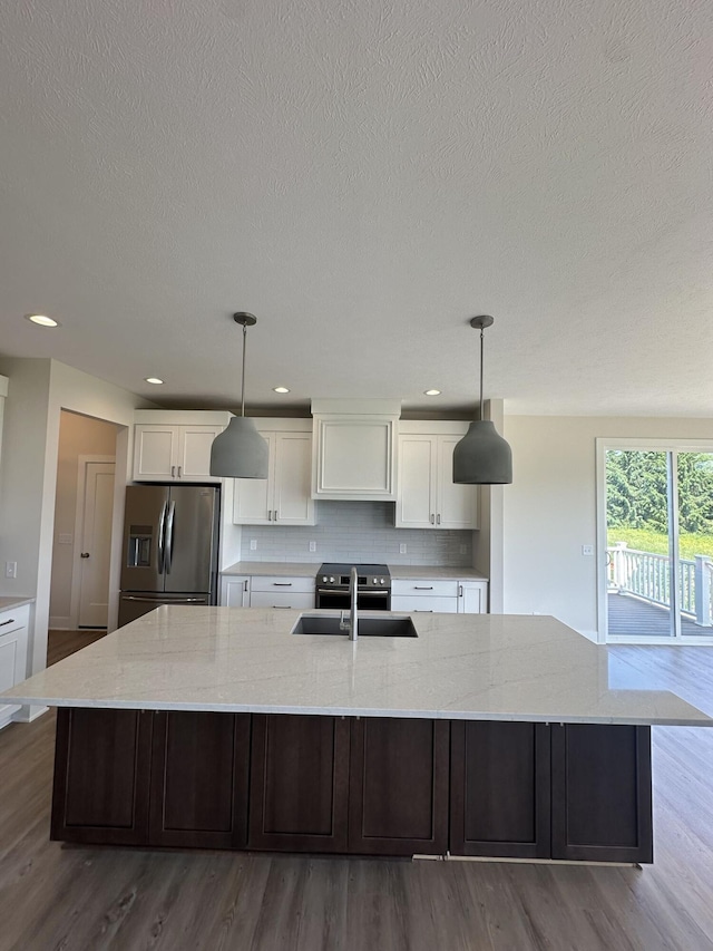 6669 Yamoto Way Lot 7, Douglas, MI 49406 - kitchen featuring stainless steel fridge, a textured ceiling, white cabinetry, a large island with sink, and tasteful backsplash