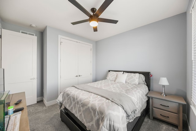 carpeted bedroom with a closet, visible vents, baseboards, and ceiling fan
