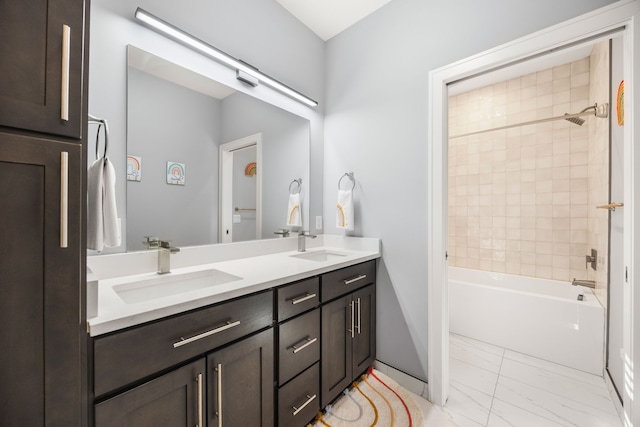 bathroom featuring double vanity, marble finish floor, bathing tub / shower combination, and a sink