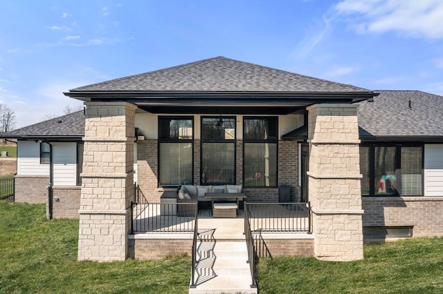 rear view of property featuring an outdoor living space, roof with shingles, and brick siding