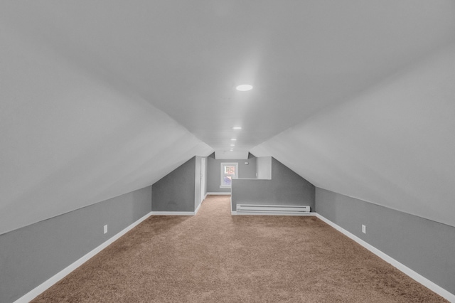 additional living space with a baseboard radiator, lofted ceiling, carpet flooring, and baseboards