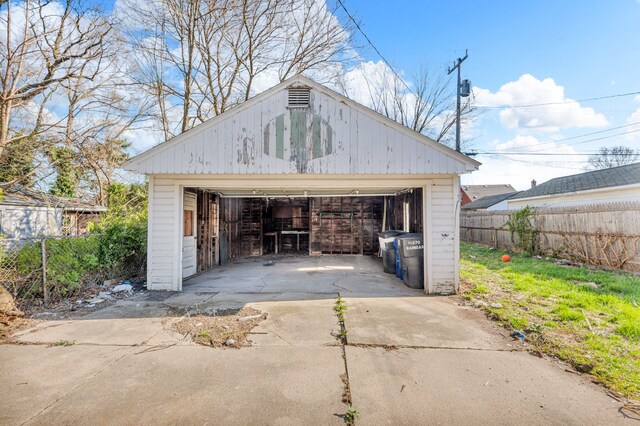 detached garage featuring fence