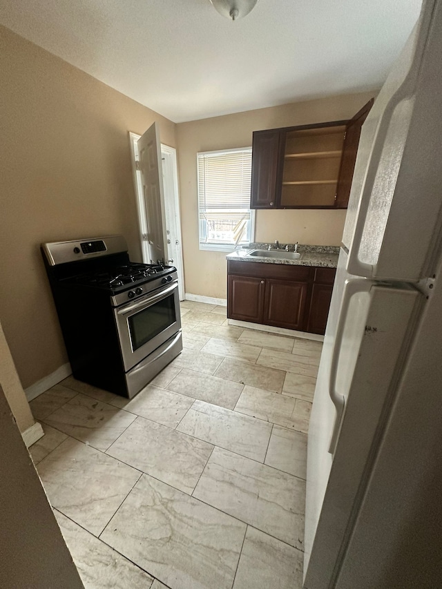 15913 Petoskey Ave, Detroit, MI 48238 - kitchen featuring dark brown cabinets, open shelves, a sink, baseboards, and gas range