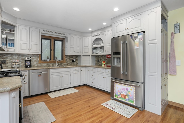 826 Hendricks Dr, Monroe, MI 48162 - kitchen with light wood finished floors, stainless steel appliances, a sink, white cabinetry, and decorative backsplash