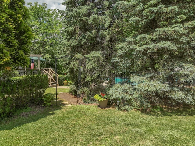 view of yard featuring a fenced in pool, stairs, and a deck