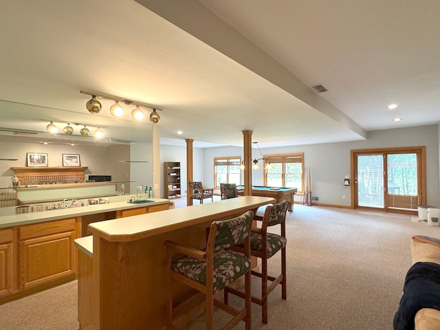 interior space featuring light carpet, open floor plan, a sink, and light countertops