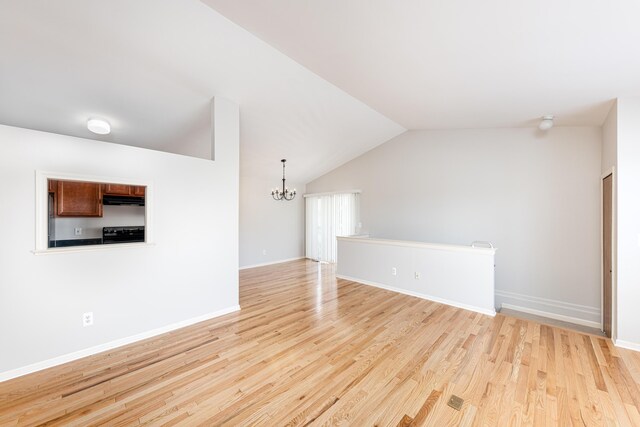 interior space with baseboards, light wood-style flooring, vaulted ceiling, and a notable chandelier