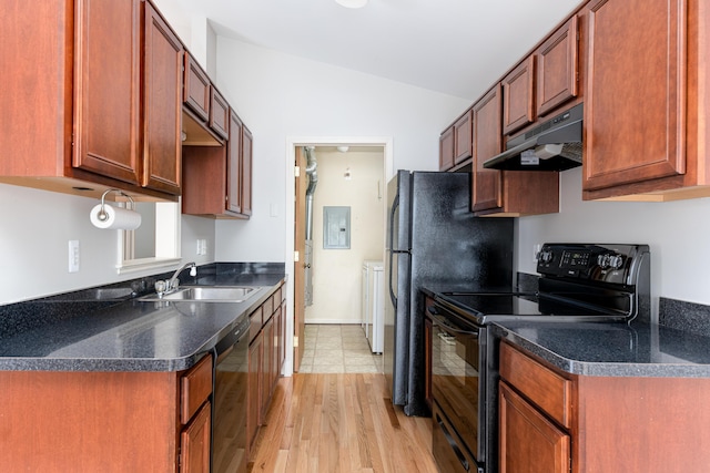 kitchen featuring lofted ceiling, under cabinet range hood, dark countertops, a sink, and black appliances