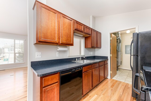 kitchen with a sink, range with electric cooktop, dark countertops, light wood-style floors, and black dishwasher
