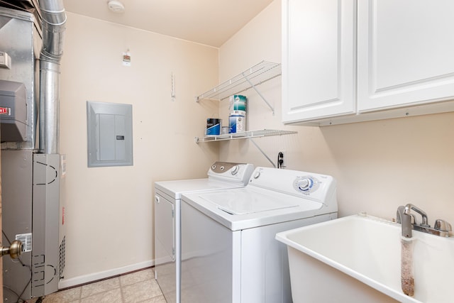 laundry area with a sink, electric panel, washer and dryer, cabinet space, and baseboards