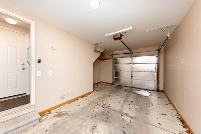 garage with a garage door opener and baseboards