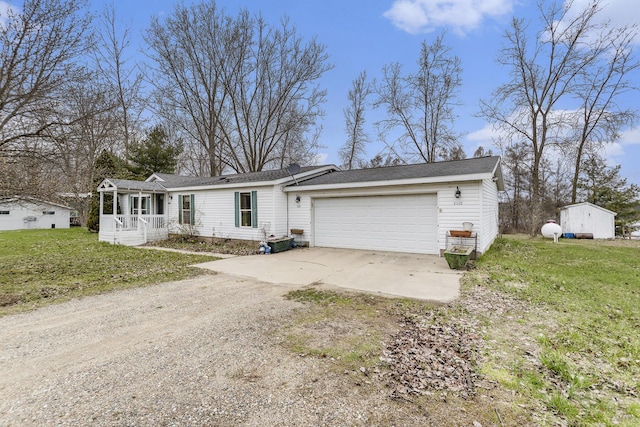 view of front of property featuring an attached garage, dirt driveway, and a front lawn