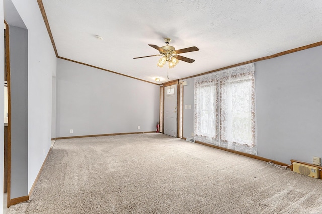 unfurnished room with visible vents, carpet flooring, ceiling fan, and crown molding