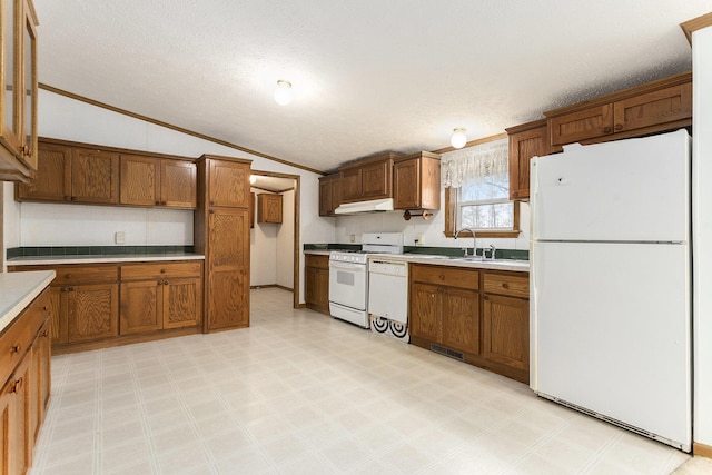 kitchen featuring lofted ceiling, under cabinet range hood, a sink, white appliances, and crown molding