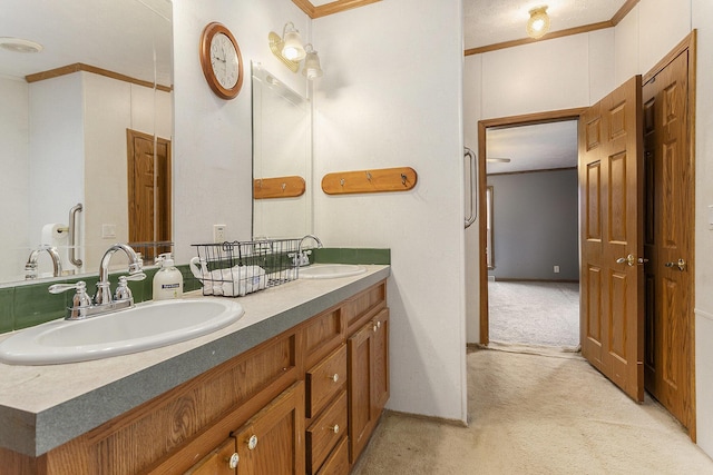 bathroom featuring double vanity, ornamental molding, and a sink