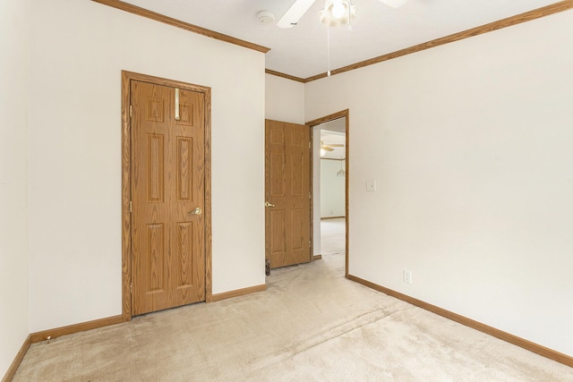 unfurnished bedroom featuring a ceiling fan, ornamental molding, baseboards, and light carpet