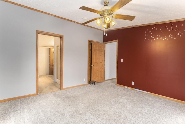 unfurnished bedroom with carpet floors, ensuite bath, crown molding, and baseboards