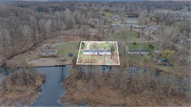 aerial view with a water view and a wooded view