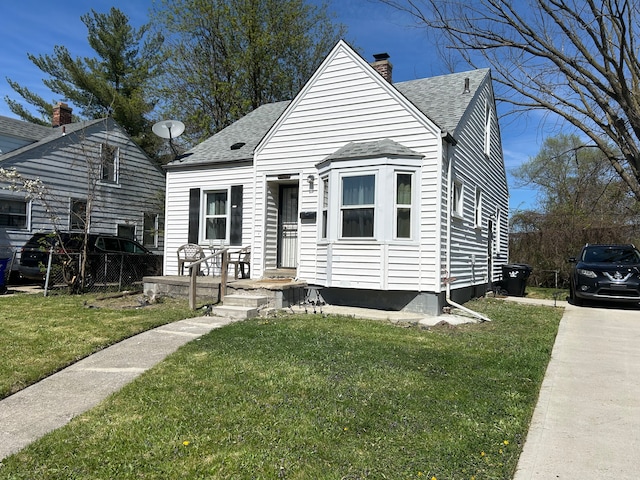 bungalow-style home featuring a front yard, a chimney, and roof with shingles