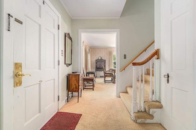 foyer entrance featuring stairs, light carpet, and crown molding
