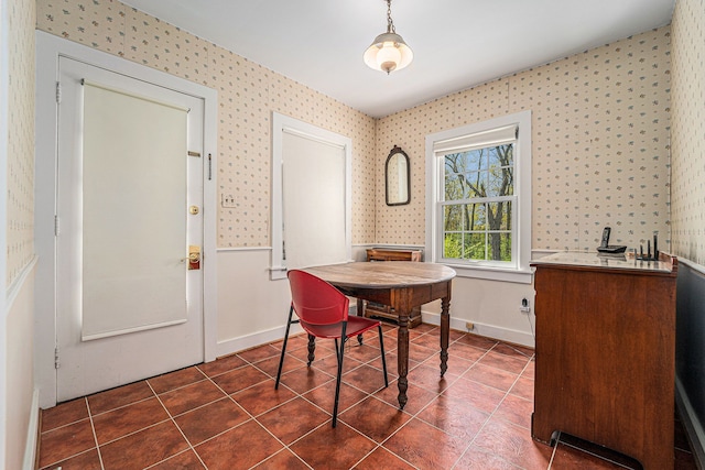 dining area with wallpapered walls, dark tile patterned floors, and baseboards